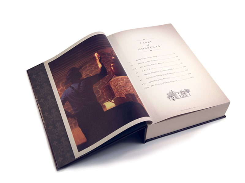 Uncle Nearest Launch Book – Open - which depicts a painting of Nathan Nearest Green from behind as he examines the color of the whiskey while standing in front of a copper whiskey distiller